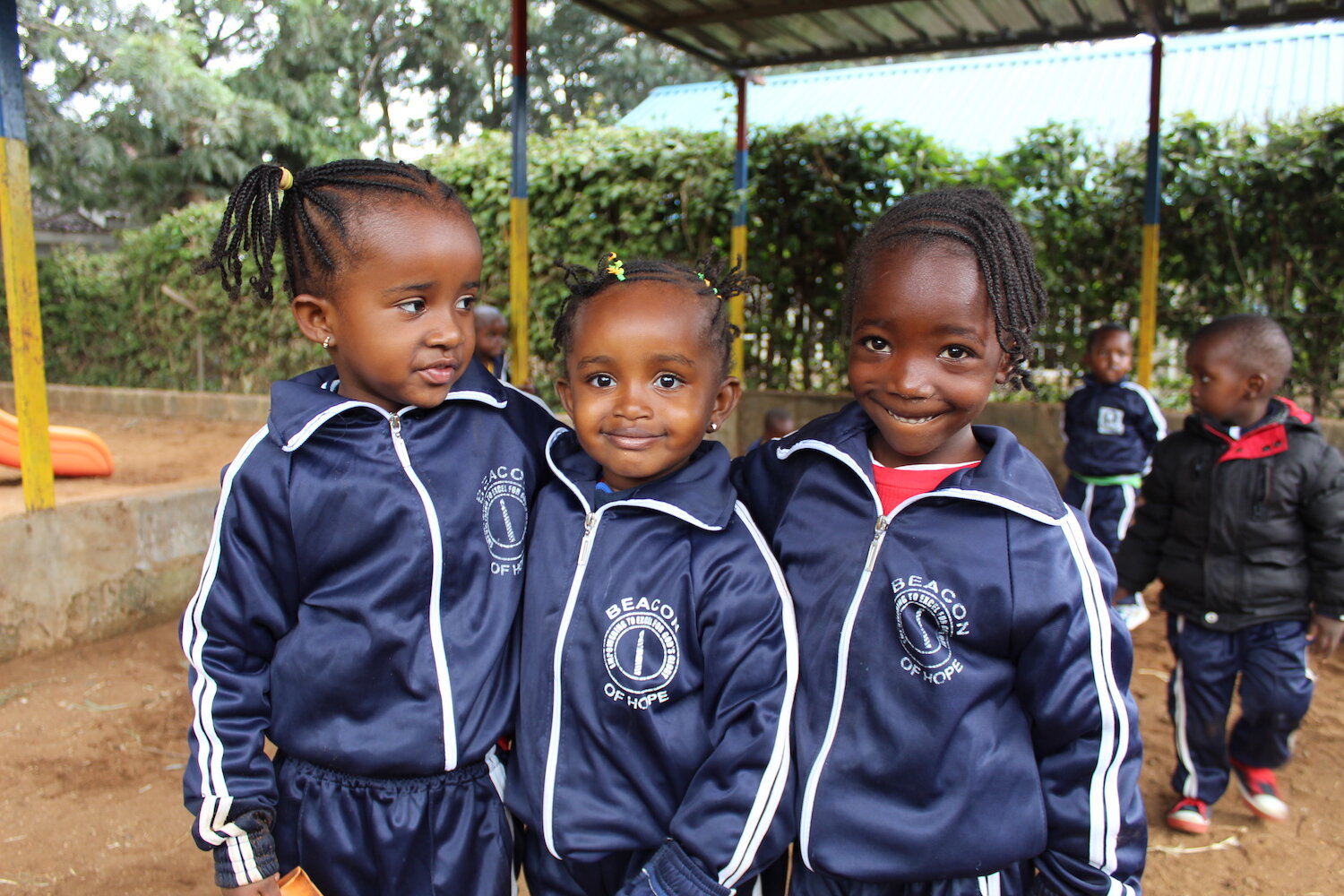 three young beacon of hope academy students smiling