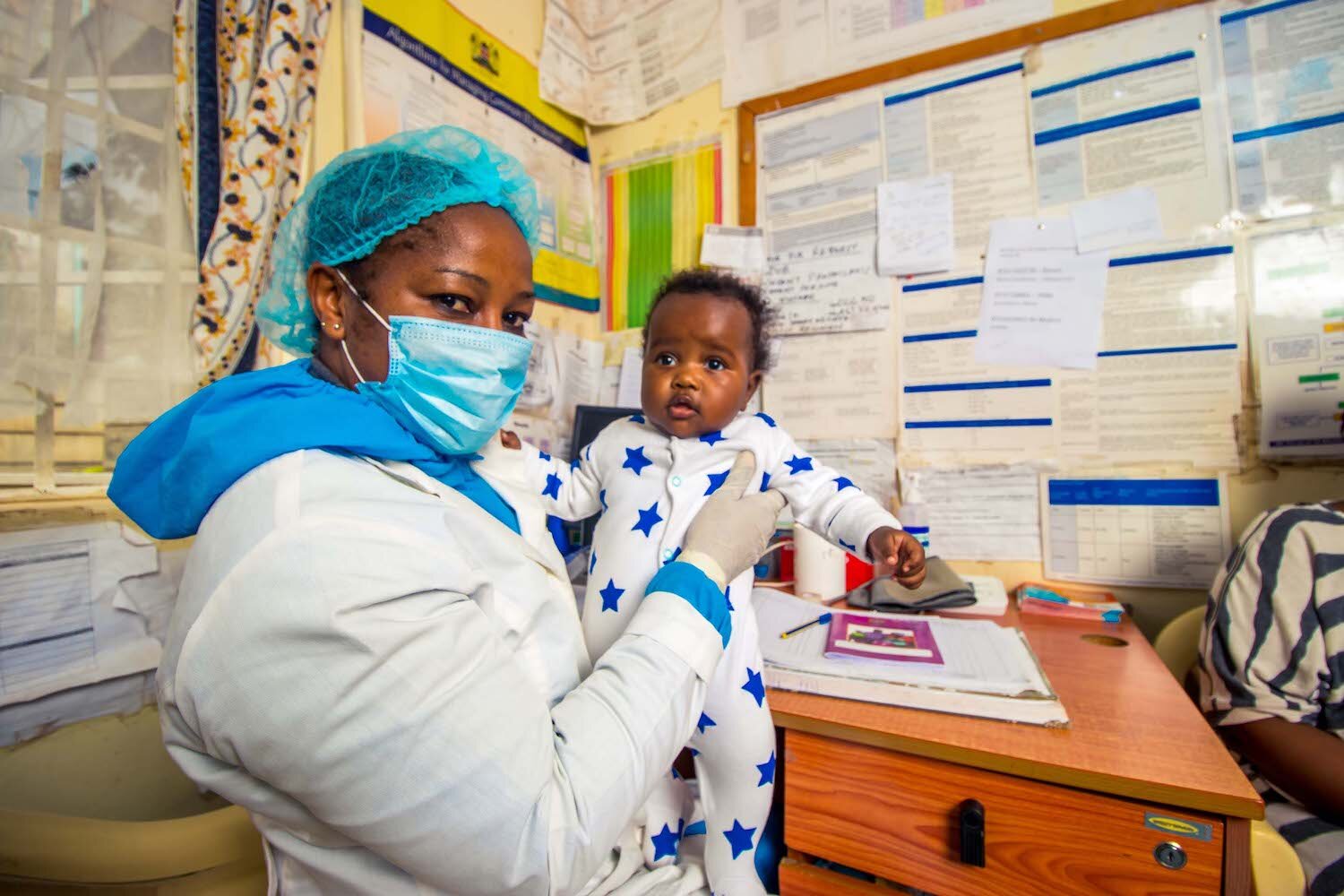 beacon of hope health worker holding baby