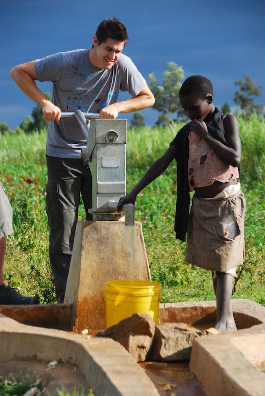 team member pumping clean well water into kid’s water can
