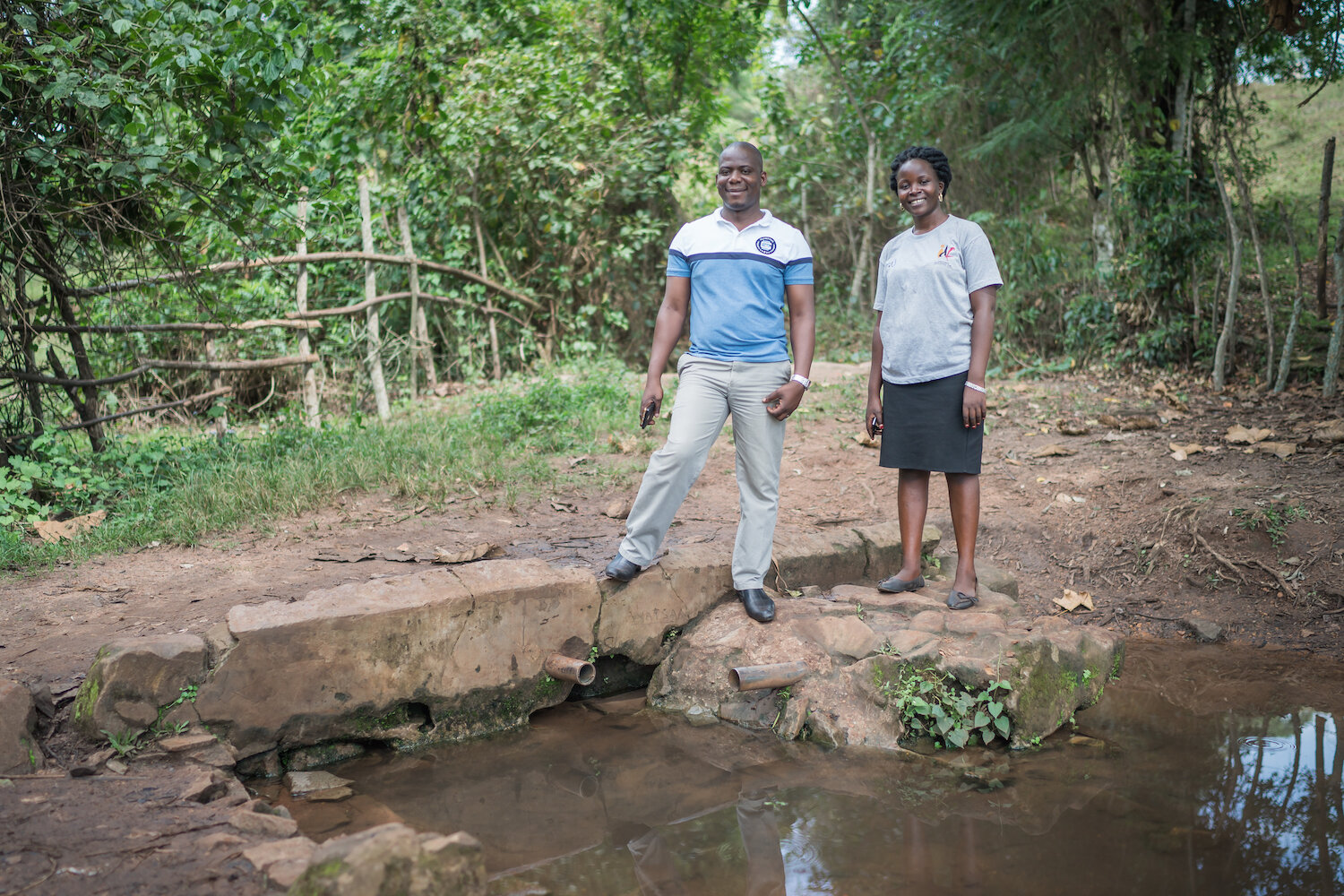 geoffrey and staff member stand next to water point